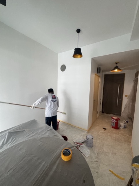 Everyday Renovation painter applying white Nippon Vinilex 5000 paint in a Singapore home, illustrating A Guide to Nippon Vinilex 5000 Painting Costs.